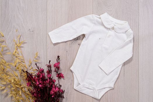 baby clothes concept. white suit for boy and girl on wooden background