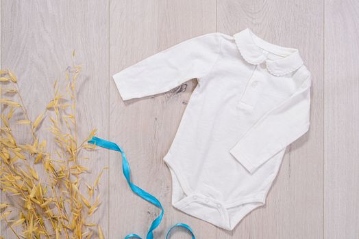 baby clothes concept. white suit for boy on wooden background