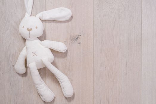 soft toy in the shape of a rabbit on wooden background