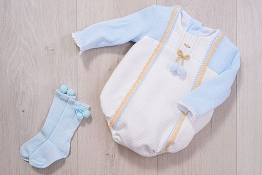baby clothes concept. white and blue suit for boy on wooden background