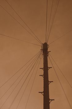 Sepia telegraph pole with numerous wires attached