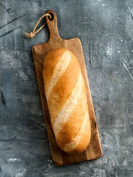 British White Bloomer or European Baton loaf bread on gray background. Top view or flat lay. Copy space for text or design. Vertical.