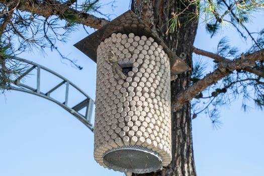 Birdhouse made from corks from wine bottles. Birdhouse on a pine tree.