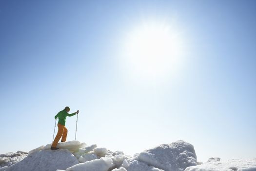 Young adult man outdoors with walking sticks exploring icy landscape