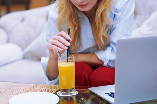 Woman relaxing at the hotel lobby and blogging via laptop