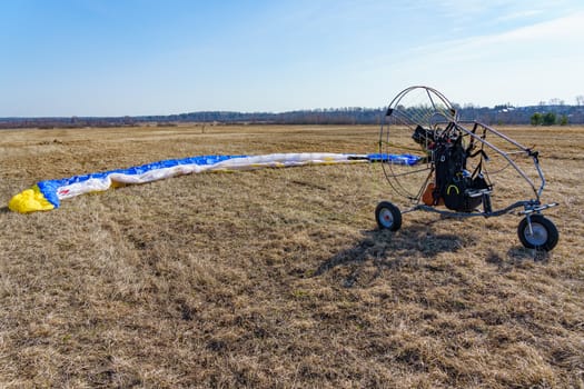 paraglider stands on the field on a sunny day prepared for flight