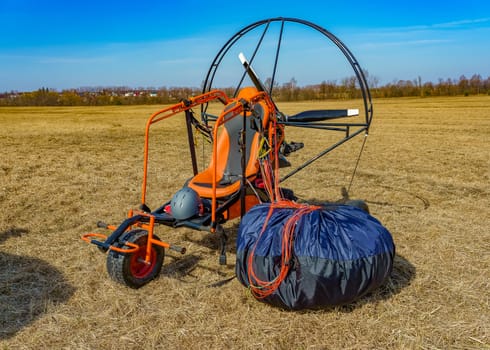 paraglider stands on the field on a sunny day prepared for flight