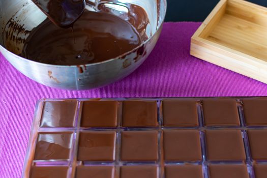 Pour the hot chocolate into the candy molds. The process of home cooking healthy sweets without sugar.