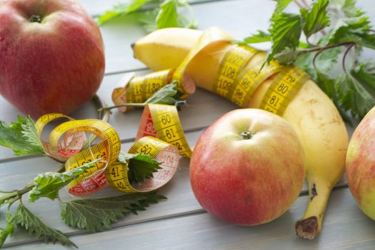 The dessert of fruit, green fresh nettle and centimeter close up on the wooden table