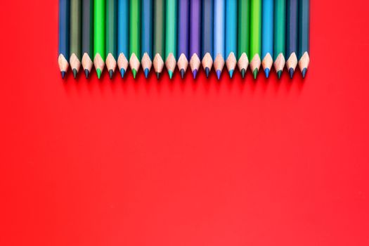 Diversity concept. row of mix color pencil on red background
