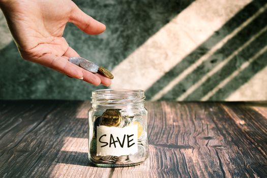 save money, woman put coins in glass jar for money saving financial concept