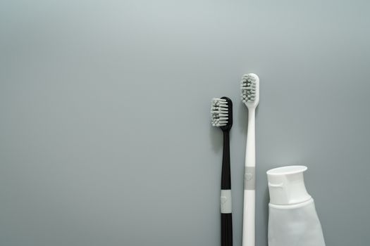 couple of toothbrush with toothpaste on gray background