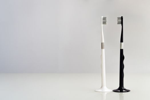 couple of black and white toothbrush on gray background, love and clean
