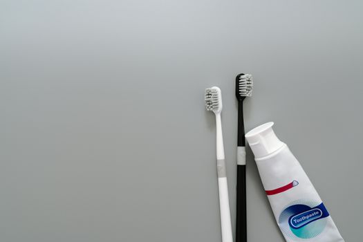 couple of toothbrush with toothpaste on gray background, healthcare concept
