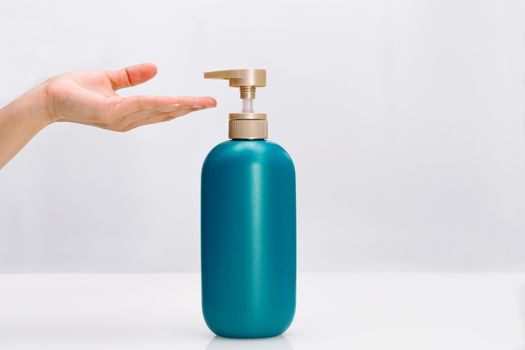 women hand apply hair shampoo conditioner bottle on white background. Beauty And Body Care Concept