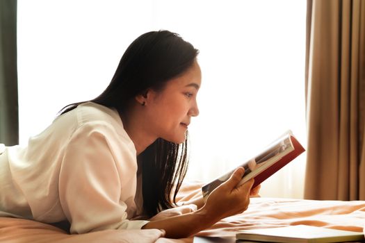 woman lay on bed reading the blank book