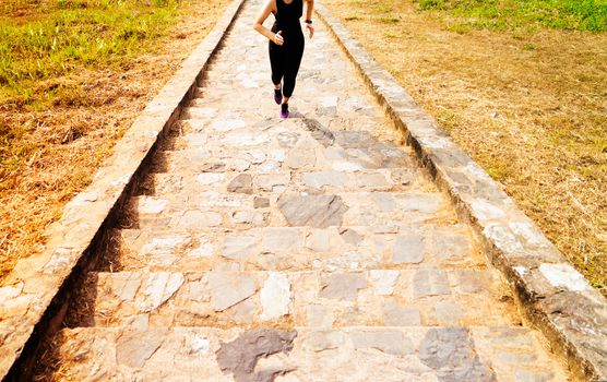 young sport woman running outdoor upstairs on blue sky