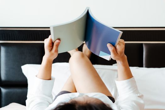 woman lay on bed reading the blank book