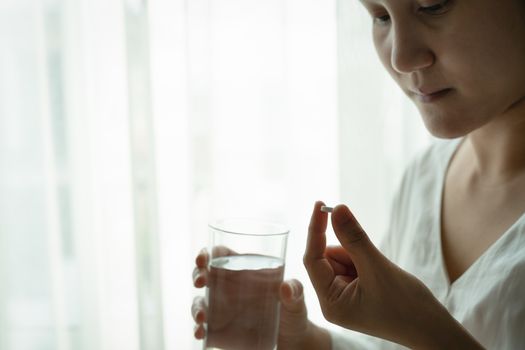headache women hand hold medicine with a glass of water, healthcare and medicine recovery concept