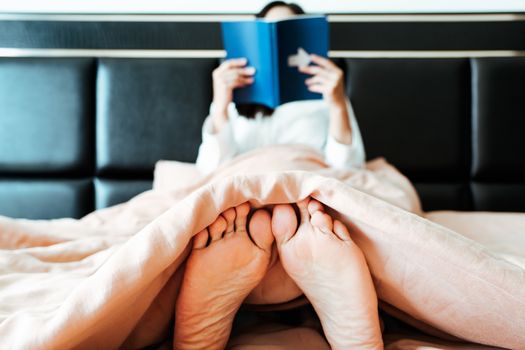 relax foot of woman sitting on bed reading the book