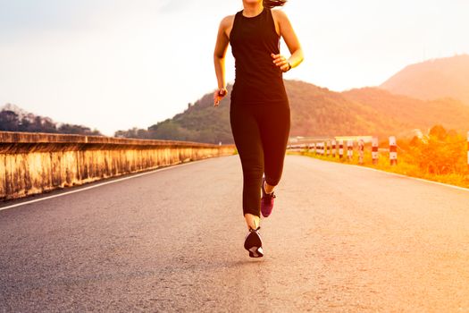 sport woman running on a road. Fitness woman training at sunset