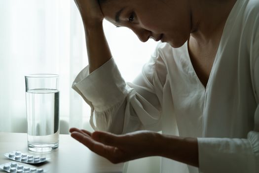 headache women hand hold medicine with a glass of water, healthcare and medicine recovery concept