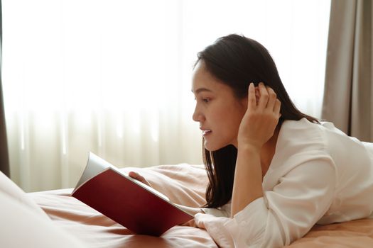 woman lay on bed reading the blank book