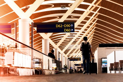 SHANGHAI, CHINA - FEB 2019: traveler with travel bag or luggage walking in the airport terminal walkway for air traveling