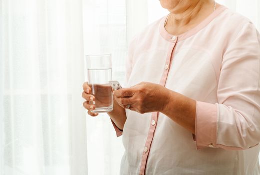 senior women take medicine with a glass of water, healthcare and medicine recovery concept