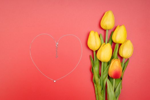 International Womens Day with flowers and heart shape necklace on red background