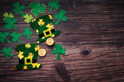 St Patricks day, golden coins, festive hat and green Shamrocks on wooden