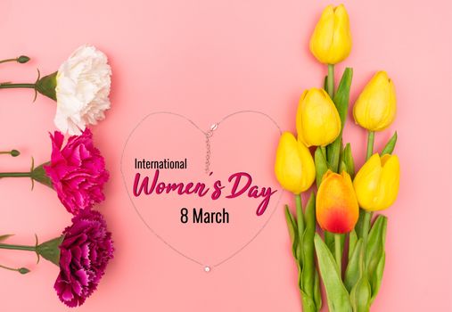 International Womens Day with flowers and heart shape necklace on pink background