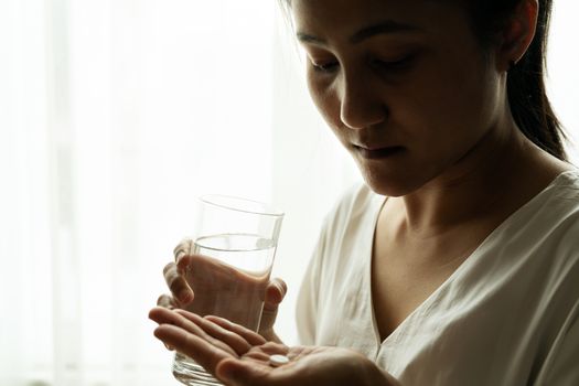 depressed women hand hold medicine with a glass of water, healthcare and medicine recovery concept