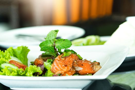 Spicy Salmon Salad with fresh mint and basil, Thai food style. Home made food. Concept for a tasty and healthy meal