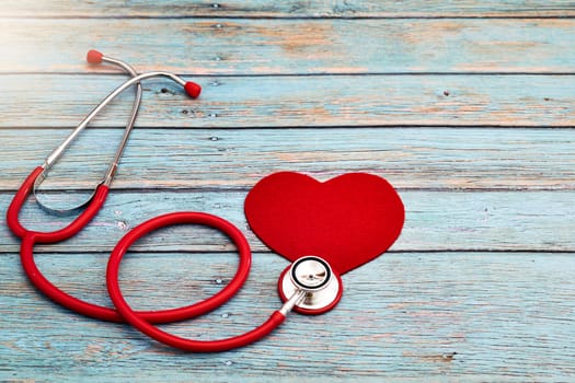 World health day, healthcare and medical concept, red stethoscope and red heart on the blue wooden background