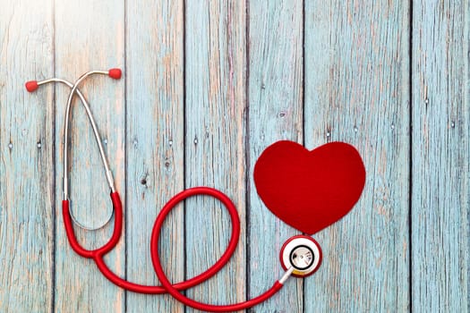 World health day, healthcare and medical concept, red stethoscope and red heart on the blue wooden background