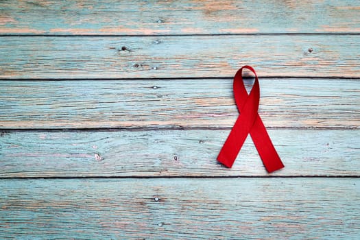 World health day, healthcare and medical concept, red ribbon on the blue wooden background