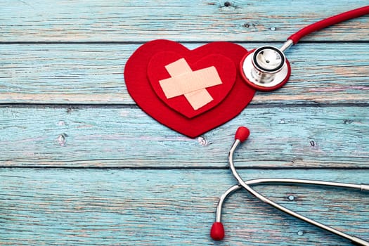 World health day, healthcare and medical concept, red stethoscope and red heart on the blue wooden background