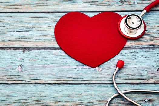 World health day, healthcare and medical concept, red stethoscope and red heart on the blue wooden background