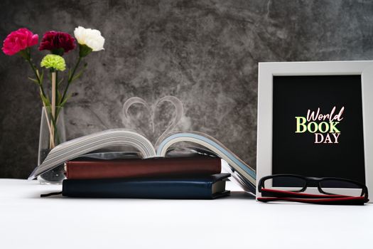 Love story book with open page of literature in heart shape and photo frame