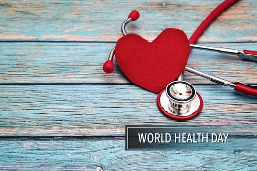 World health day, healthcare and medical concept, red stethoscope and red heart on the blue wooden background