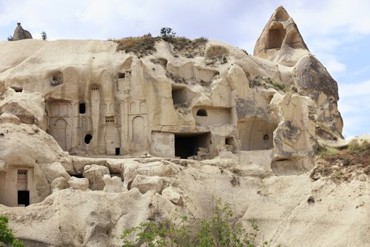 Old ancient temple and residential caves carved into the sandstone mountains in Cappadocia