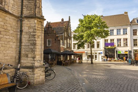 square next to the great church of the city of breda you can see constructions of old style and business. Netherlands Netherlands