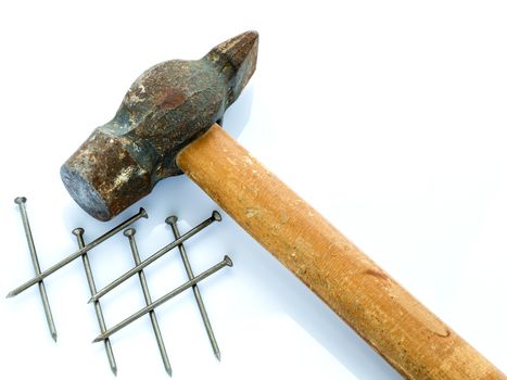 An old hammer with a wooden handle and a bunch of nails. Objects on a light background