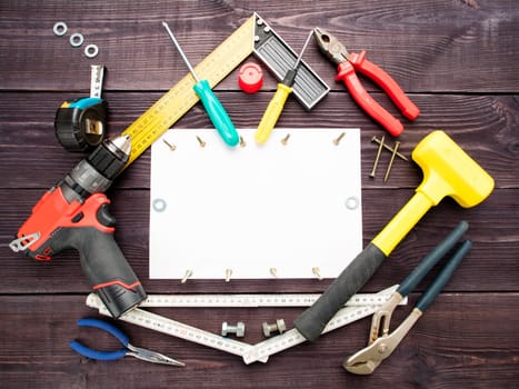 The tool building on the wooden background around the white sheet of paper