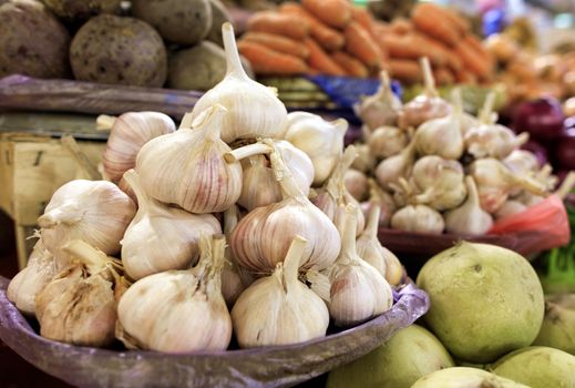 Close-up of dry garlic heads against other ripe vegetables in a blurred form - Ukrainian national natural antibiotic.