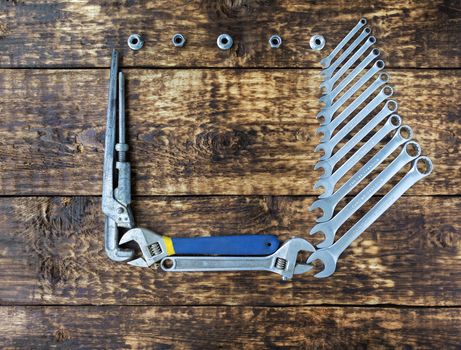 Set of combination wrenches and old adjustable wrenches on an old wooden boards background with a place for copy space