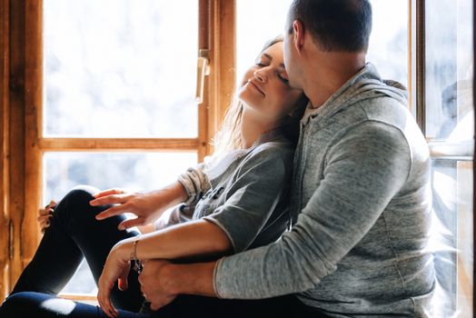 guy and girl in the house near the window overlooking a snowy landscape