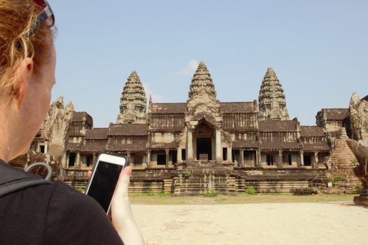 east entrance angkor wat cambodia girl taking photo on smart phone