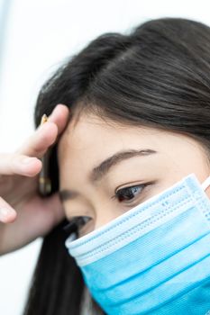 Close up woman with headache wearing  protective mask  for protection against virus Covid-19